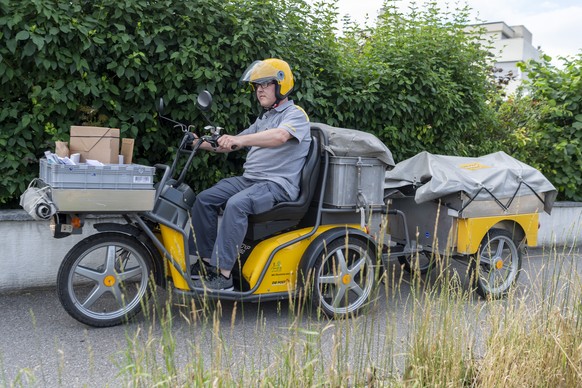 Poestler Vincenzo Visca nimmt einen Recycling-Sack mit, in Reinach, am Freitag, 25. Juni 2021. Beim Pilotprojekt in der Gemeinde Reinach BL, in Zusammenarbeit mit der Schweizerischen Post, koennen lee ...