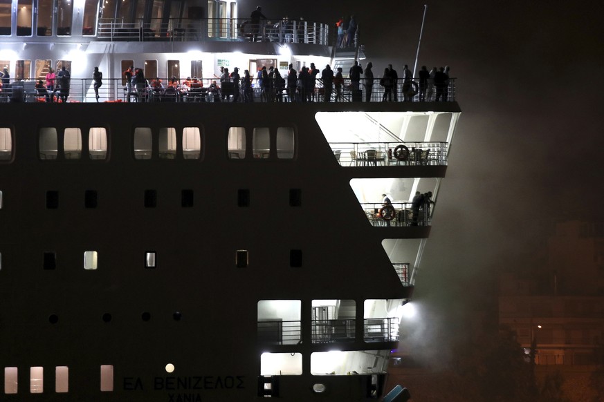 Smoke rises as passengers stand at the top of the deck of Eleftherios Venizelos ship at the port of Piraeus, near Athen Wednesday, Aug. 29 2018. The ferry with hundreds of passengers and crew arrived  ...