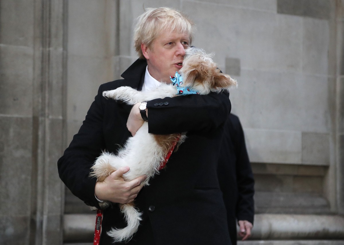 FILE - Britain's Prime Minister and Conservative Party leader Boris Johnson holds his dog Dilyn as he leaves after voting in the general election at Methodist Central Hall, Westminster, London, T ...
