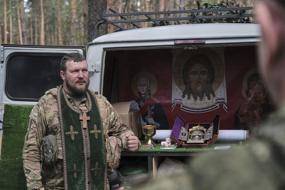 In this photo taken from video distributed by Russian Defense Ministry Press Service on Sunday, April 20, 2025, .an Orthodox priest, left, conducts a religion service on eve of Orthodox Easter at an u ...