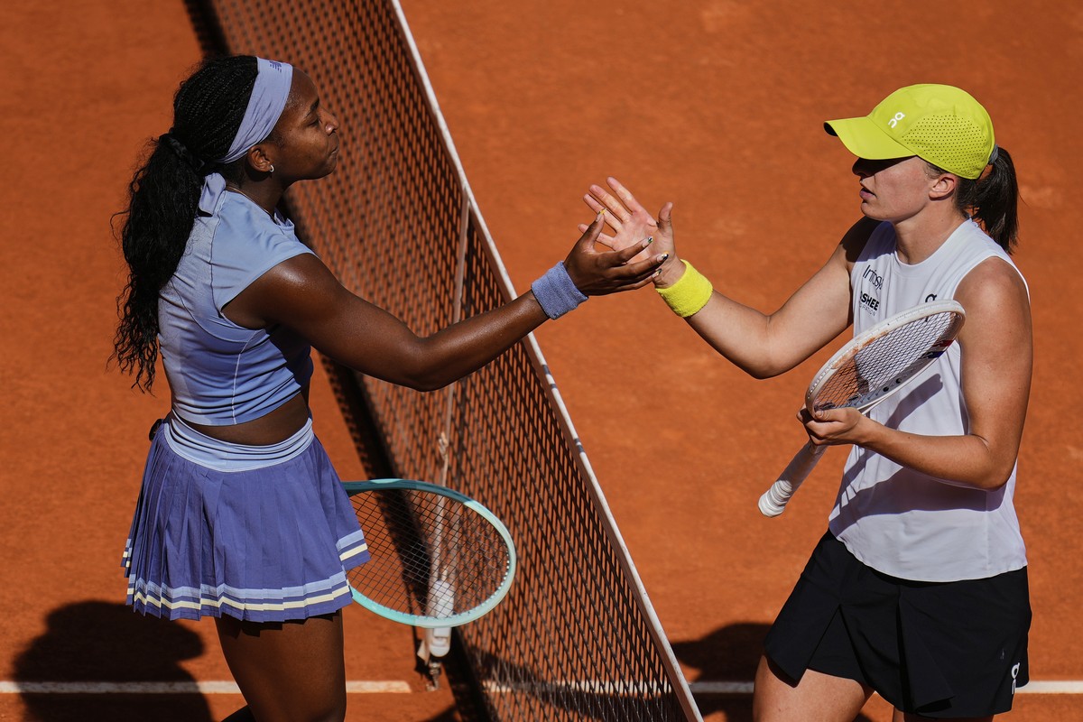 United States' Coco Gauff, left, shakes hands with Iga Swiatek of Poland at the end of the match during the Madrid Open tennis tournament in Madrid, Spain, Thursday, May 1, 2025. (AP Photo/Manu F ...