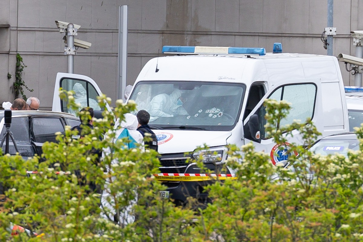epa11340381 French forensic police inspect a vehicle at the toll station of Incarville, near Rouen, in the North of France, where gunmen ambushed a prison van on 14 May 2024, killing two prison guards ...