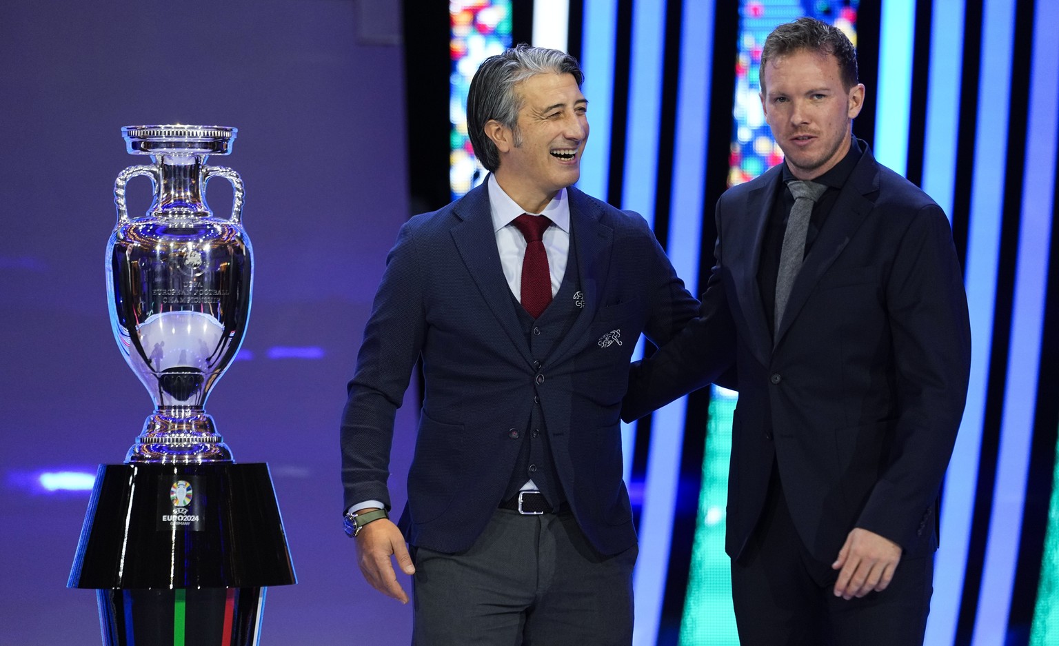 The head coaches of Switzerland Murat Yakin, left,and Germany Julian Nagelsmann, right, pose next to the trophy after the draw for the UEFA Euro 2024 soccer tournament finals in Hamburg, Germany, Satu ...