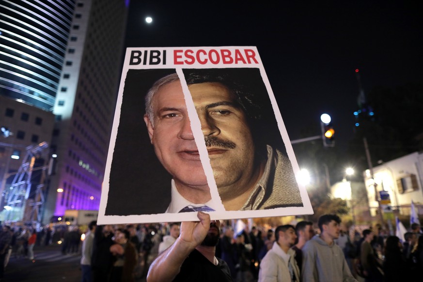epa10436731 A protester holds a placard against Israeli Prime Minister Benjamin Netanyahu during a protest in Tel Aviv, Israel, 28 January 2023. Thousands gathered to protest against the newly-formed  ...