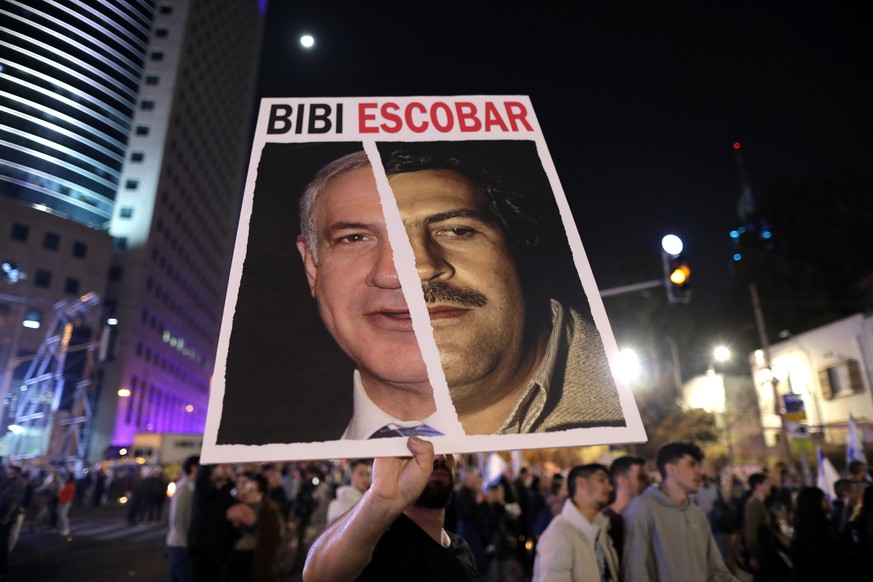 epa10436731 A protester holds a sign against Israeli Prime Minister Benjamin Netanyahu during a protest in Tel Aviv, Israel, January 28, 2023. Thousands gathered to protest against the newly formed…