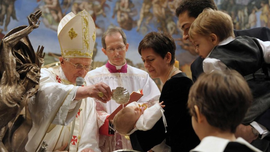 In this photo released by the Vatican's L'Osservatore Romano newspaper, Pope Benedict XVI, in white at left at the microphone, baptizes the infant of Paolo Corvini a Vatican state employee, at right w ...