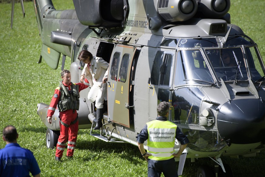 epa06160089 Swiss President Doris Leuthard (C-R) climbs from a helicopter as she arrives to inspect the site after a landslide in Bondo, Graubuenden in southern Switzerland, 24 August 2017. The villag ...