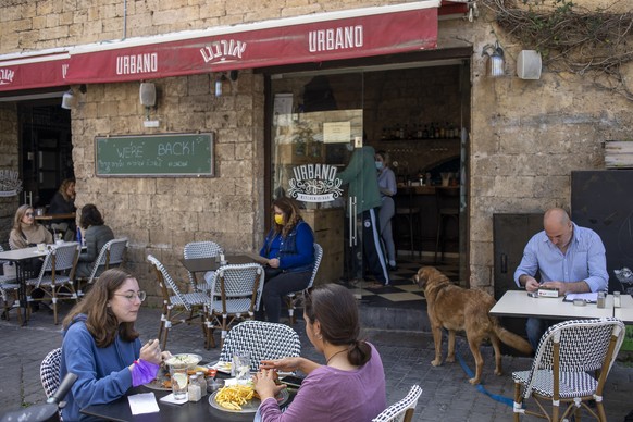 FILE - In this March 7, 2021, file photo, people eat in a restaurant as restrictions are eased following months of government-imposed shutdowns, in Tel Aviv, Israel. While Israel provides a glimpse of ...