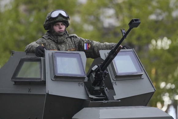 A Russian soldiers sits atop his military vehicle driving along Tverskaya street to attend a rehearsal for the Victory Day military parade in Moscow, Russia, on Tuesday, April 29, 2025. (AP Photo/Pave ...