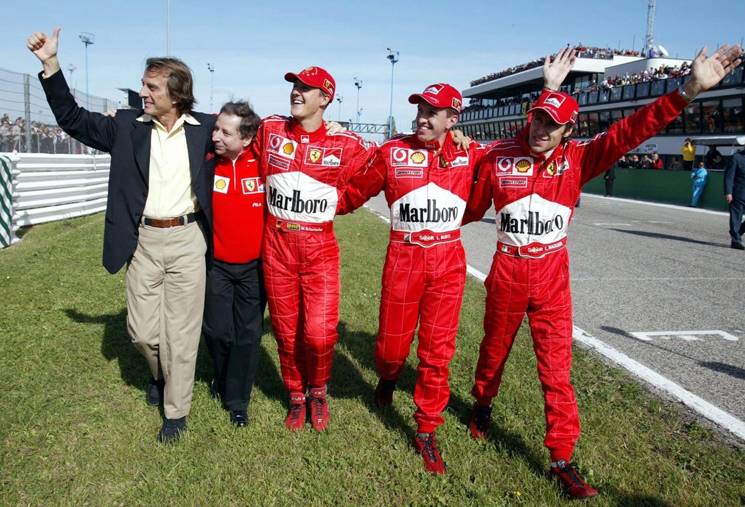 Ferrari president Luca Cordero di Montezemolo, left, team manager Jean Todt, driver Michael Schumacher of Germany, test drivers Luciano Burti and Luca Badoer wave to fans during the Ferrari day at the ...