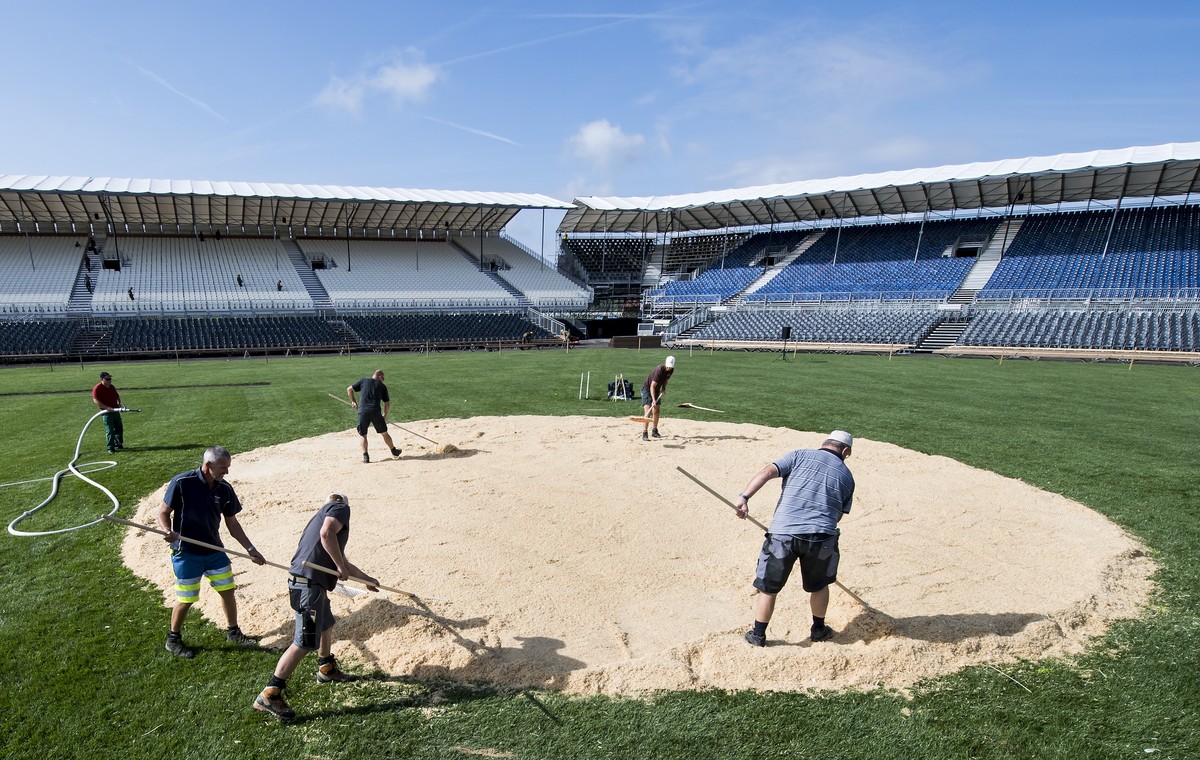 Des ouvriers apportent la sciure au milieu de l'arene sur le site de la Fete federale de lutte et des jeux alpestres (Eidgenoessisches Schwing- und Aelplerfest), Estavayer 2016, ce vendredi 19 ao ...