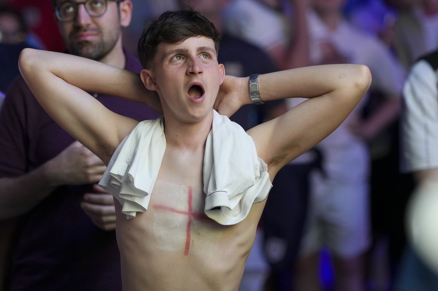 An English soccer fan yawns as he watches on a big screen the Group C match between the England and Slovenia at the Euro 2024 soccer tournament in Cologne, Germany, Tuesday, June 25, 2024. (AP Photo/M ...