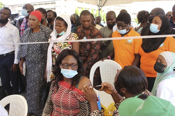 A Nigeria civil servant receives a dose of the AstraZeneca coronavirus vaccine, before she is allow access to her office in Abuja, Nigeria , Wednesday, Dec. 1, 2021. Nigeria has detected its first cas ...