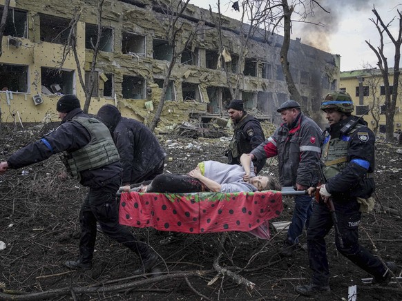 FILE - Ukrainian emergency employees and volunteers carry an injured pregnant woman from a maternity hospital damaged by shelling in Mariupol, Ukraine, Wednesday, March 9, 2022. The woman and her baby ...