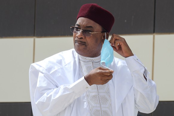 epa08518549 Nigerien President Mahamadou Issoufou takes off his face mask as he arrives for a group picture during the G5 Sahel Summit in Nouakchott, Mauritania, 30 June 2020. The leaders of the G5 Sa ...