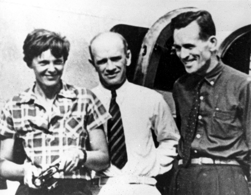 FILE - In this file photo taken on or about July 2, 1937, American aviator Amelia Earhart, left, and her navigator, Fred Noonan, right, pose beside their plane with gold miner F.C. Jacobs at Lae, New  ...