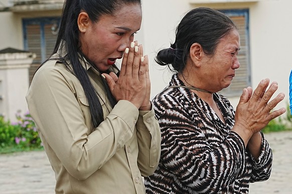 Local villagers pray as they donate their personal belongings for the frontline army force at a sidewalk in Srey Snam district in Siem Reap province, Cambodia, Saturday, July 26, 2025. (AP Photo/Heng  ...