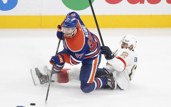 Florida Panthers&#039; Sam Reinhart (13) and Edmonton Oilers&#039; Connor McDavid (97) battle for the puck during the third period in Game 5 of the NHL hockey Stanley Cup Final in Edmonton, Alberta, S ...