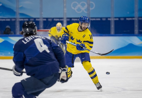 epa09752599 Mikko Lehtonen (L) of Finland in action against Marcus Kruger (R) of Sweden during the Men&#039;s Ice Hockey preliminary round match between Finland and Sweden at the Beijing 2022 Olympic  ...