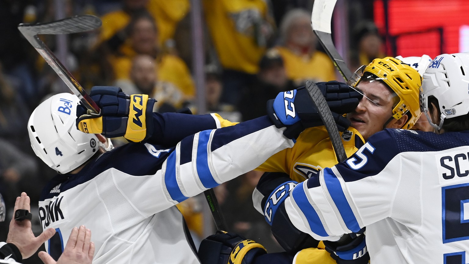 Winnipeg Jets defenseman Neal Pionk, left, scuffles with Nashville Predators left wing Tanner Jeannot during the second period of an NHL hockey game Thursday, Jan. 20, 2022, in Nashville, Tenn. (AP Ph ...