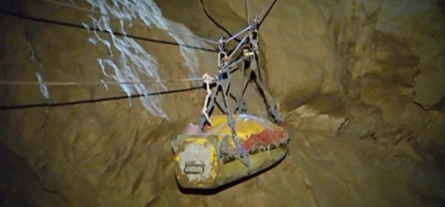 Die Trage mit dem verletzten Höhlenforscher wird in einer Transportschale an Seilzügen durch das Höhlensystem transportiert.&nbsp;