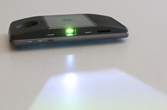 In this Tuesday, July 26, 2016, photo taken in New York, the Moto Z Force Droid phone is shown with a projector module attached to the back. The optional module projects whatever&#039;s on the phone s ...