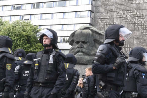 epa06976829 German police in riot gear patrols around the statue of Karl Marx as right wing protesters gather at the place where a man was stabbed overnight 25 August 2018, in Chemnitz, Germany, 27 Au ...
