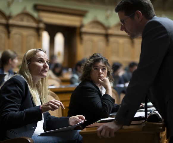Andrea Zryd, SP-BE, links, spricht mit Lars Guggisberg, SVP-BE, rechts, vor Tamara Funiciello, SP-BE, Mitte, waehrend der Herbstsession der Eidgenoessischen Raete, am Donnerstag, 19. September 2024 im ...