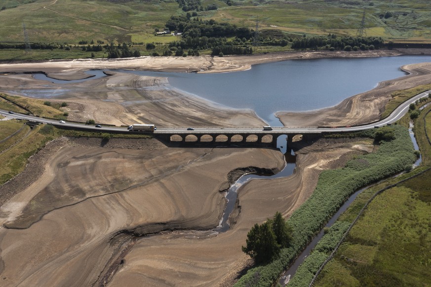 Traffic crosses a bridge at Woodhead Reservoir in West Yorkshire, England, Monday, July 18, 2022 as water levels dip dangerously low amid record high temperatures in the UK. Millions of people in Brit ...