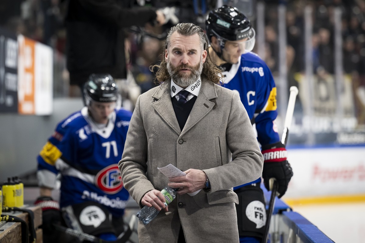 Der Freiburger Cheftrainer Christian Dube kommt auf die Spielerbank mit Freiburger Julien Sprunger und Freiburger Killian Mottet, beim Eishockey Meisterschaftsspiel der National League A zwischen dem  ...
