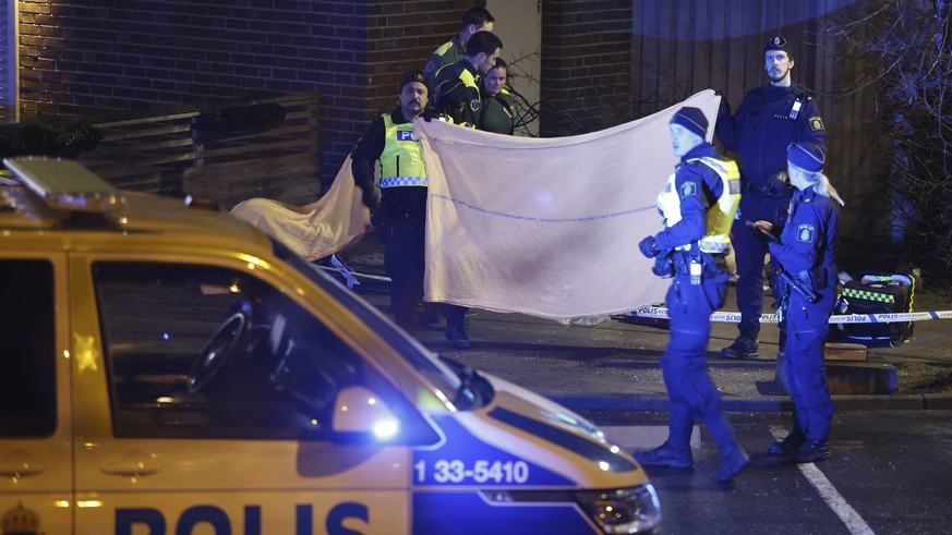 Police stand in the area where a man was found shot dead in Solna outside Stockholm Friday, Jan. 20, 2023. (Christine Olsson//TT News Agency via AP)