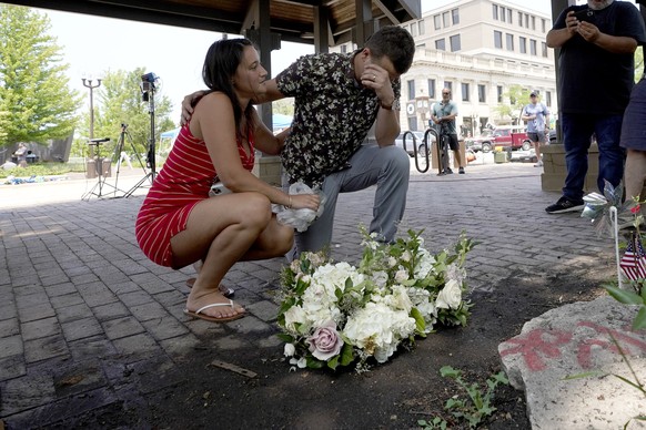 Brooke and Matt Strauss, who were married Sunday, pause after leaving their wedding bouquets in downtown Highland Park, Ill., near the scene of Monday&#039;s mass shooting Tuesday, July 5, 2022, in Hi ...