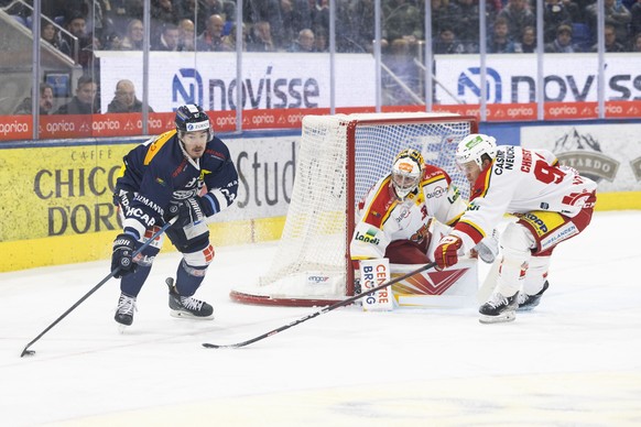 Ambri&#039;s player Dario Buergler, left, fights for the puck with Bienne&#039;s player Luca Christen, right, in front of Biel&#039;s goalkeeper Harri Saeteri, center, during the preliminary round gam ...