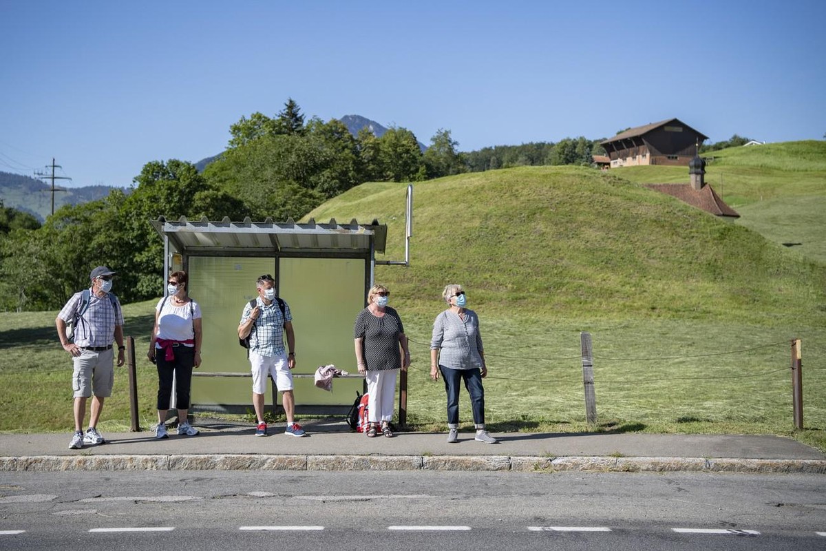 Eine Gruppe Wanderer wartet auf das Postauto bei der Haltestelle Sagendorf in Emmetten im Kanton Nidwalden am zweiten Tag der Schutzmaskenpflicht im oeffnetlichen Verkehr waehrend der Corona-Pandemie  ...