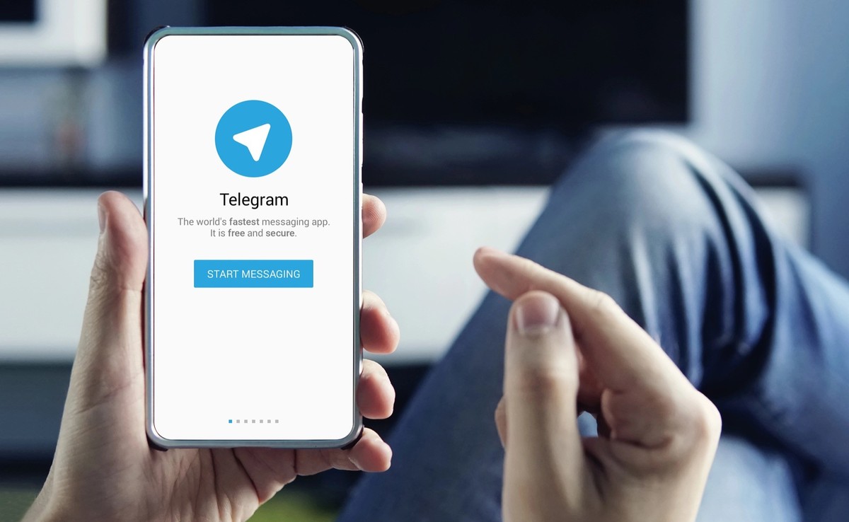 Mann mit Smartphone und Telegram-App (Symbolbild).