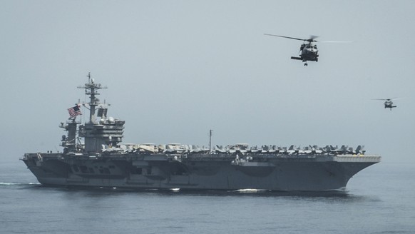 In this April 13, 2015 photo released by U.S. Navy Media Content Services, helicopters fly from the aircraft carrier USS Theodore Roosevelt during a vertical replenishment with the aircraft carrier US ...