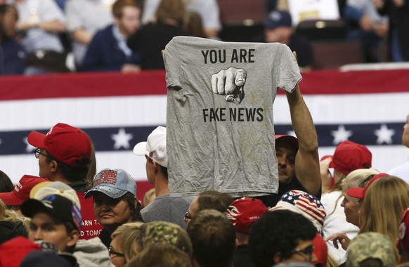 FILE - In this Oct. 4, 2018 file photo, a Trump supporter holds up a T-shirt reading &quot;You Are Fake News&quot; before a rally by President Donald Trump in Rochester, Minn. Local members of the med ...