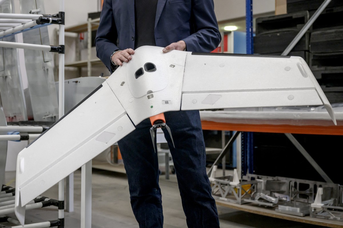 Delair's co-founder Bastien Mancini holds an 'Oskar' drone, capable of carrying warheads for military use, at the company's factory in Labege, south-western France, on April 11, 20 ...