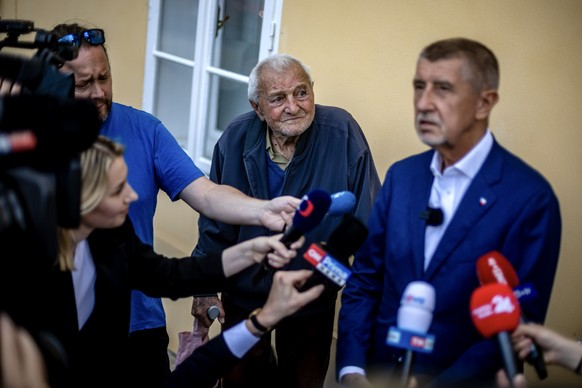 epa11395464 An elderly man listens as former Czech prime minister and ANO (Yes) opposition movement leader, Andrej Babis (R), speaks to the media after casting his vote for the European elections in P ...