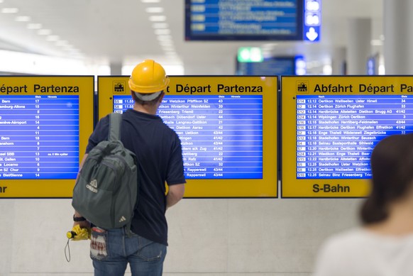 A commuter studies an electronic timetable at Loewenstrasse train station in Zurich Main Station, Switzerland, pictured on July 14, 2014. (KEYSTONE/Christian Beutler)

Ein Pendler betrachtet im Bahnho ...