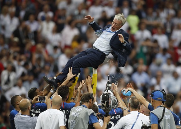 France head coach Didier Deschamps is thrown into the air by his players as they celibate after defeating Croatian in the match between France and Croatia at the 2018 soccer World Cup in the Luzhniki  ...