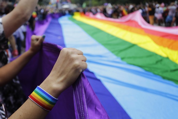 Revelers at the annual gay pride parade hold up a giant rainbow flag in Sao Paulo, Brazil, Sunday, June 3, 2018. This year the parade focused on the general elections scheduled for October, with the t ...