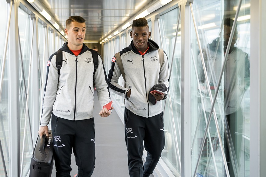 Switzerland&#039;s soccer players Granit Xhaka, left, and Breel Embolo, right, react before taking the aircraft at the EuroAirport Basel Mulhouse, in Basel, Switzerland, Sunday, October 8, 2017. Switz ...