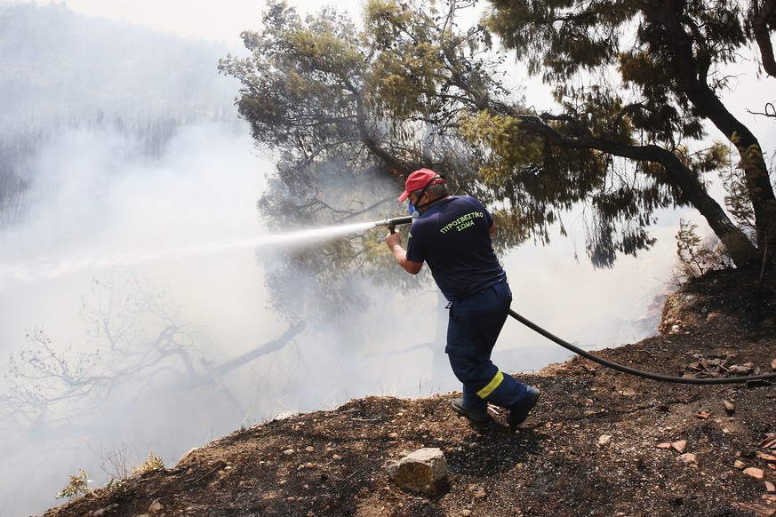 epa10755428 A firefighter tries to extinguish a forest fire in the area of ​​Kandili Megara, West Attica, Greece, July 19, 2023. West Attica and Loutraki experienced another difficult night of wildfires that...