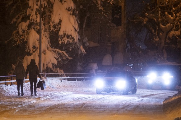 Ein Paar ist bei starkem Schneefall unterwegs in St. Moritz, am Samstag, 5. Dezember 2020. (KEYSTONE/Alexandra Wey)