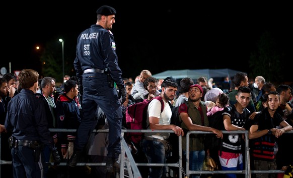 Refugees queue up for a bus, as they arrive at the border between Austria and Hungary, Heiligenkreuz, Austria, late Tuesday Sept. 15, 2015. Austria&#039;s Interior Ministry says temporary border contr ...
