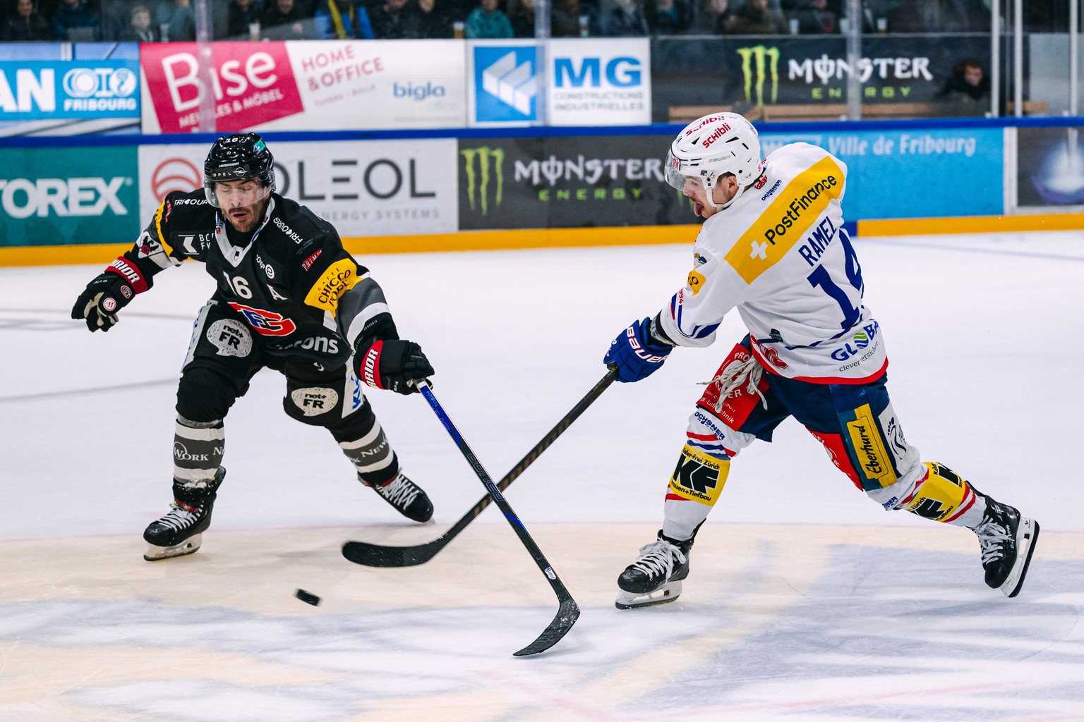 Raphael Diaz (HCFG), gauche, lutte pour le puck avec Mischa Ramel (EHCK), droite, lors du match du championnat suisse de hockey sur glace de National League entre le HC Fribourg Gotteron et le EHC Klo ...