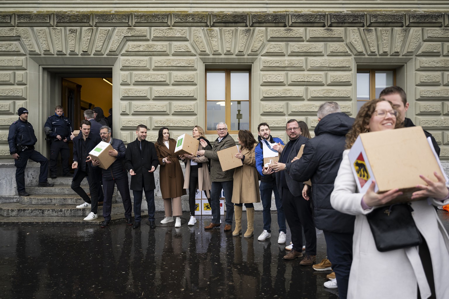 Parlamentarier, Mitglieder der Mitte-Partei und Unterstuetzer reichen die Schachteln mit den gesammelten Unterschriften weiter anlaesslich der Uebergabe fuer die Volksinitiativen &quot;Ja zu fairen AH ...
