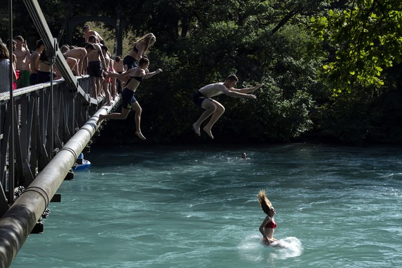 epaselect epa07676475 People jump from a bridge in the Aare River during the sunny and warm weather, in Bern, Switzerland, 27, June 2019. The forecasts predict hot weather in Switzerland with the maxi ...