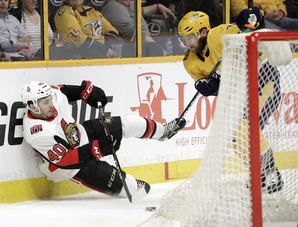 Ottawa Senators center Gabriel Dumont (40) passes the puck away from Nashville Predators defenseman Yannick Weber (7), of Switzerland, as he falls in the third period of an NHL hockey game Monday, Feb ...